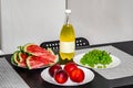 Plates with fruits and a bottle of yellow drink stand on a table against a white wall background. Peaches, grapes and watermelon Royalty Free Stock Photo