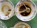 Plates of leftover food, skewers with soy sauce and remaining goat