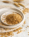 Plates of raw dry rye grain on white table close up. Healthy alternative low gluten diet