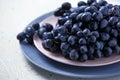 Plates with ripe sweet grapes on light table Royalty Free Stock Photo