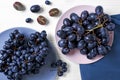 Plates with ripe sweet grapes on light table Royalty Free Stock Photo