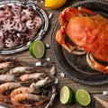 Plates with seafood on wooden background. Fresh octopus, shrimps and crab served with lime, lemon and seashells. Restaurant dish.