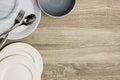 Plates with spoon and fork on a wooden table.