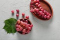 Plates with tasty grapes on textured background