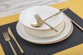 Plates and utensils, Plate, Bowl and golden cutlery on dining table, side view. Modern craft ceramic tableware, cutlery on the Royalty Free Stock Photo