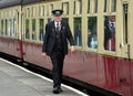 Platform guard walking alongside train carriages at Grosmont station, North Yorkshire Moors, UK Royalty Free Stock Photo