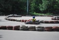 The platform for karting in the Moscow Sokolniki park. Summer sunny day the teenager rides the platform on the racing machine.