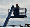 A platform lift raises a worker above a bridge