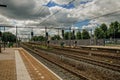 Platform, railroad rails and signaling at train station under blue cloudy sky at Weesp. Royalty Free Stock Photo