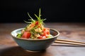 plating colorful poke bowl with raw fish cubes