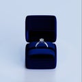 A platinum diamond ring with a 3D design in a blue jewelry box.