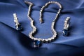 Platinum necklace and earrings with a diamond and blue precious