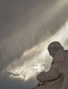 Plato's marble statue, the ancient Greek philosopher in deep thoughts, under an impressive cloudy sky with sun patches.