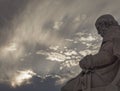 Plato marble statue, the ancient Greek philosopher in deep thoughts, under an impressive cloudy sky with sun patches.