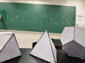 Platonic solids in front of a math blackboard