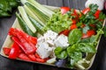 Platter of assorted fresh vegetables and feta cheese on light wooden background. Royalty Free Stock Photo