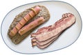 Pair of Hot Dogs On Brown Bread Slice With Three Extra Bacon Rashers On White Porcelain Platter Isolated On White Background Royalty Free Stock Photo