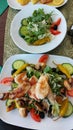 Salad with chicken and vegetables. Wooden table in a restaurant.