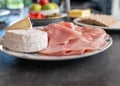 Platter with cold cuts and cheese on a dinner table. Domestic life Royalty Free Stock Photo