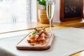 Platter: cold salmon bruschetta and greens with a glass of champagne Royalty Free Stock Photo