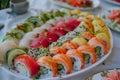 A platter displaying a variety of colorful sushi rolls on a table, A plate of colorful sushi rolls arranged tastefully