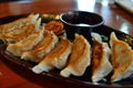 platter of gyoza with dipping sauce on a restaurant table