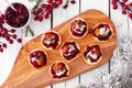 Platter of holiday appetizers with cranberries, goat cheese and pecans, top view serving scene on white wood