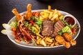 Platter of mixed meats, salad and French fries Royalty Free Stock Photo