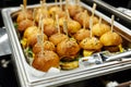 A platter of savory mini burgers with toothpicks and condiments