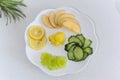 Platter of sliced fruits and vegetable on white background, top view Royalty Free Stock Photo