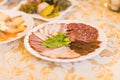 Platter of sliced ham,salami and cured meat with vegetable decoration on festive table Royalty Free Stock Photo