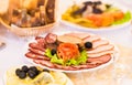 Platter of sliced ham,salami and cured meat with vegetable decoration on festive table Royalty Free Stock Photo