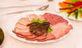 Platter of sliced ham,salami and cured meat with vegetable decoration on festive table. Royalty Free Stock Photo