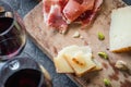 Platter with Spanish ham jamon serrano or Italian prosciutto crudo, sliced Italian hard cheese, glasses of red wine Royalty Free Stock Photo