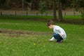 Play based learning - Small child picks flowers from a field