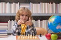 Play chess. Chess for intelligent kid. Child genius, smart pupil playing logic board game. Clever school boy thinking Royalty Free Stock Photo