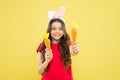 Play with food. Spring tradition. Playful child yellow background. Holy Week activities. Healthy food. Child bunny ears