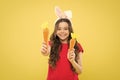 Play with food. Spring tradition. Playful child yellow background. Holy Week activities. Healthy food. Child bunny ears