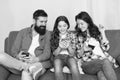 Play game application. Family surfing internet. Family leisure. Online family. Mom dad and daughter relaxing on couch Royalty Free Stock Photo