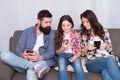 Play game application. Online family. Mom dad and daughter relaxing on couch. Family spend weekend online. Child little Royalty Free Stock Photo