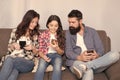 Play game application. Online family. Mom dad and daughter relaxing on couch. Family spend weekend online. Child little Royalty Free Stock Photo