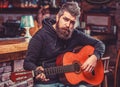 Play the guitar. Beard hipster man sitting in a pub. Live music. Guitars and strings. Bearded man playing guitar Royalty Free Stock Photo