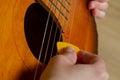 Play the guitar with a yellow pick, the pick gives about the strings of the guitar