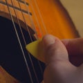 Play the guitar with a yellow pick, the pick gives about the strings of the guitar