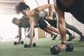 We play hard but work even harder. a fitness group using dumbbells while doing push-ups at the gym. Royalty Free Stock Photo