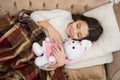 Play soft toy before go sleep. Sleep with toy. Girl enjoy evening time with favorite toy. Kid lay bed and hug bunny toy