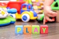Play word from colorful cubes with many toys on background