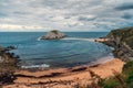 Playa de Covachos beach in Santander, Cantabria, North Spain with rocky island and sandy spit in cloudy day. Popular