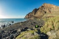 Playa del ingles beach with volcanic black sand at the atlantic ocean in La Gomera. A popular vacation spot for tourists and Royalty Free Stock Photo