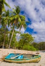 PLAYA MONTEZUMA, COSTA RICA, JUNE, 28, 2018: Outdoor view of small boat in the sand with some palm trees behind in Playa